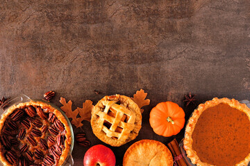 Poster - Selection of homemade autumn pies. Pecan, pumpkin and apple. Top view bottom border on a dark stone background with copy space.