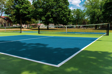 Recreational sport of pickleball court in Michigan, USA looking at an empty blue and green new court at a outdoor park. Ground View.