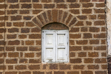 Sticker - Closeup shot of an old white window on a building brick facade