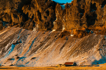 Wall Mural - A lonely house at the foot of the mountains in Iceland. Incredible landscapes of nature. Life for a social phobia