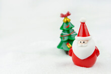 Merry Christmas And Happy New Year Concept. Cute Santa Claus Figure And Tree On Snow With Copy Space