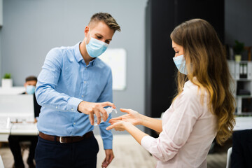 Cleaning Hands At Office Entrance Using Sanitizer