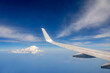 Aussicht aus einem fliegenden Flugzeug über den Wolken mit blauem Himmel als Hintergrund mit Textfreiraum