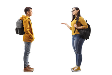 Wall Mural - Full length profile shot of a male teenager talking to a female student
