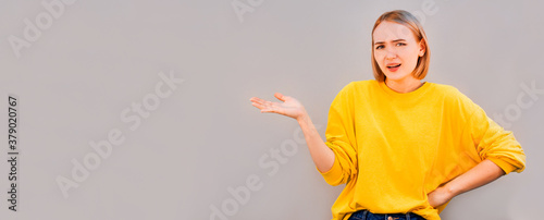 Fotomural Close up of an attractive young woman with a horrified expression clenching her
