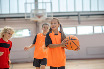 Wall Mural - Kids in bright sportswear having basketball game