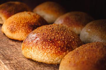 Soft and golden burger breads fresh from the oven with a wood background