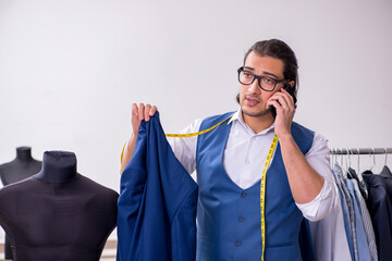 Young male tailor working at workshop