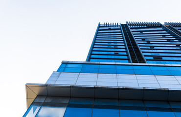 Blue glass building in the city on a clear blue morning. High-rise office building