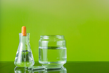  Set of chemical glassware for science experiment on gradient green background.