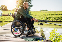 Young Disabled Man In A Wheelchair Fishing.