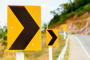 Yellow caution danger sign from a curved road