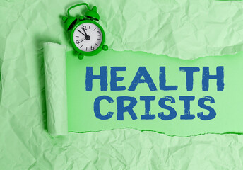 Text sign showing Health Crisis. Business photo text fitness problem that affects in more geographic areas Rolled ripped torn cardboard placed above a wooden classic table backdrop