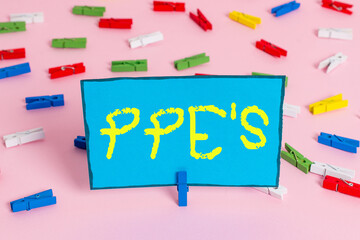 Poster - Text sign showing Ppe s is. Business photo showcasing Specialized equipment for protection against health and safety hazard Colored clothespin papers empty reminder pink floor background office pin