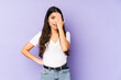 © Asier - Young indian woman isolated on purple background having fun covering half of face with palm.