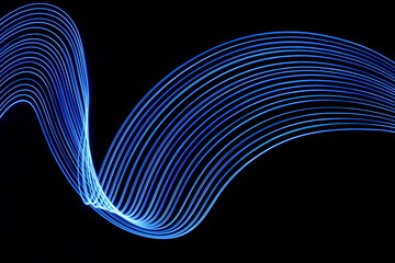 long exposure photograph of neon blue colour in an abstract swirl, parallel lines pattern against a 