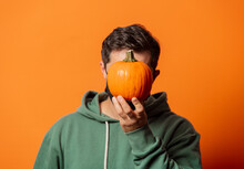 Guy In Face Mask And Green Hoodie With Pumpkin