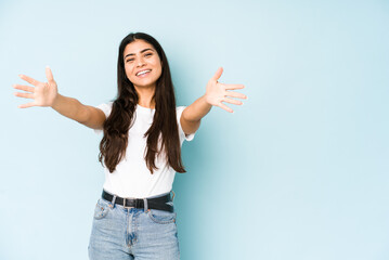 Wall Mural - Young indian woman on blue background celebrating a victory or success, he is surprised and shocked.