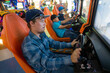 © Chepko Danil - Teenagers boy plays on the gaming car simulator in the club.