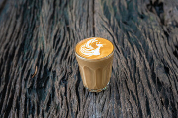 Wall Mural - Cup of latte art coffee on a wooden table