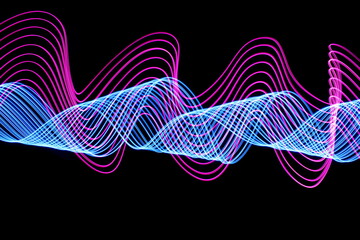 Wall Mural - Long exposure photograph of neon pink and blue colour in an abstract swirl, parallel lines pattern against a black background. Light painting photography.