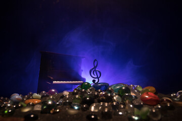 Wall Mural - Musical symbol treble clef stainless steel miniature with colorful toned light on foggy background. Selective focus