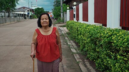 Wall Mural - Thai elderly woman in round-necked sleeveless collar walking