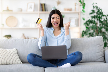 Online Credit. Joyful Lady Celebrating Success With Card And Laptop At Home