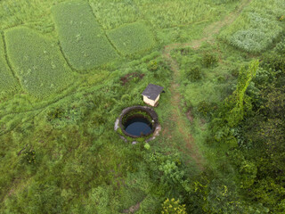 Poster - Aerial shot of a beautiful green farmland with lots of trees and a water pond