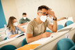 © BGStock72 - Male student wearing face protective medical mask for virus protection at lecture hall