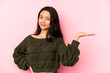 © Asier - Young chinese woman isolated on a pink background showing a copy space on a palm and holding another hand on waist.