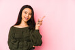 © Asier - Young chinese woman isolated on a pink background smiling cheerfully pointing with forefinger away.