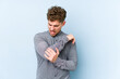 © Asier - Young blond curly hair caucasian man isolated massaging elbow, suffering after a bad movement.