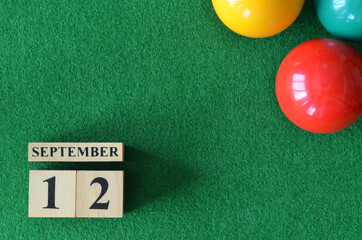 September 12, number cube with balls on snooker table, sport background.