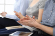 © Iryna - Business people clapping at meeting or conference, close-up of hands. Group of unknown businessmen and women in modern white office. Success teamwork, corporate coaching and applause concept