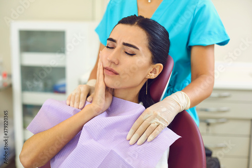 Cuadros en Lienzo Young woman is sitting in a dentist's chair and suffering from severe toothache