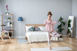 © BestForYou - Beautiful woman with hair bun in sportswear practicing yoga at home, doing Vrksasana exercise on one leg, hands in prayer namaste gesture, Tree pose.