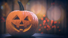 Carved Pumpkin On Halloween. Jack O Lantern Smile Face. Decoration From Fresh Pumpkins. Autumn Season. Scary Jack-o'-Lantern Face. Happy Halloween. Orange Lights Bokeh On Background.