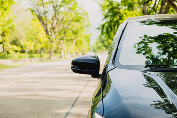 View front of travel by black car on the asphalt road in the summer holiday. Automobile for lifestyle trip on highway in freedom vacation with copy space.