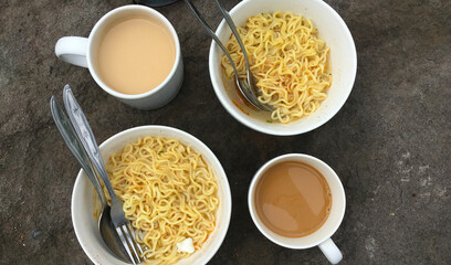 two bowls of instant noodles and coffee milk on the table