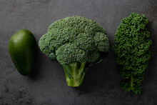 Avocado, Kale And Broccoli, Detox Dieting Concept. Green Vegetables On A Dark Stone Background, Top View