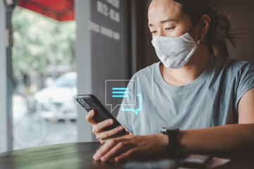 Aufkleber - smart asian female new lifestyle Wear a face mask and use a smartphone typing, chatting conversation in chat box icons pop up. Social media marketing concept. during the Coronavirus COVID-19 pandemic.