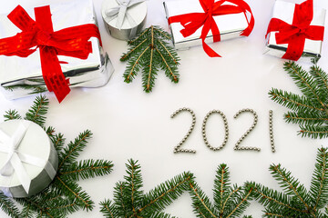 Christmas composition 2021 of silver balls and gifts with branches of a Christmas tree on a white background. Decorative flat lay, top view, copy space