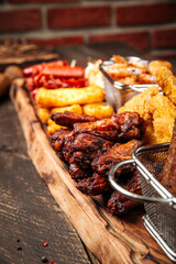 Wall Mural - Fried beer snacks on the wooden board with sauces