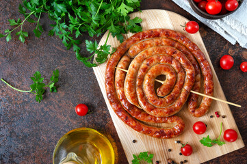 Wall Mural - Delicious homemade sausages, baked  rings on skewers, with cherry tomatoes. Oktoberfest snack. Summer picnic dish