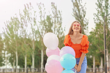 Sticker - Young woman with balloons outdoors