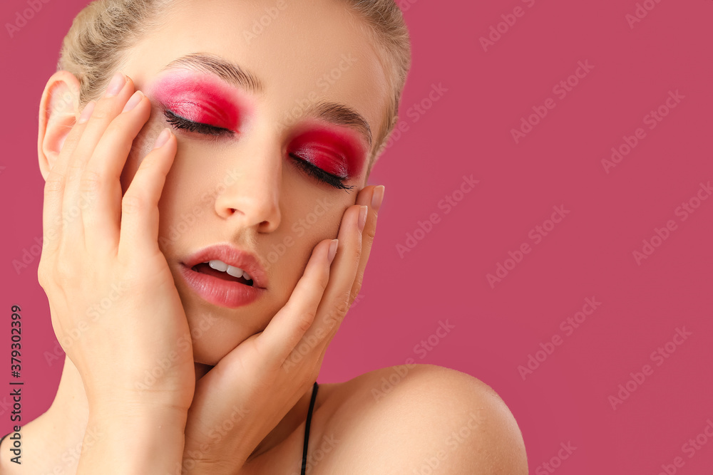 Young woman with beautiful eyeshadows on color background