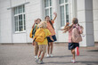 © zinkevych - Schoolchildren meeting after lessons in school yard and feeling good