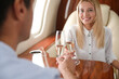 © New Africa - Couple clinking glasses of champagne during flight