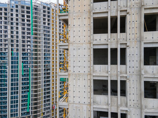 Drone aerial view of real estate building in construction house development concept. Crane tower in the construction site. Riverside office or apartment skyscrapers and the cityscape in background